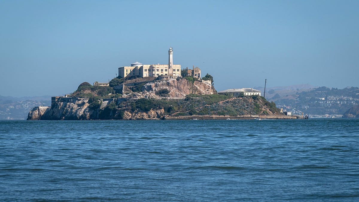 A general view of Alcatraz Island in San Francisco Bay with water surrounding it.